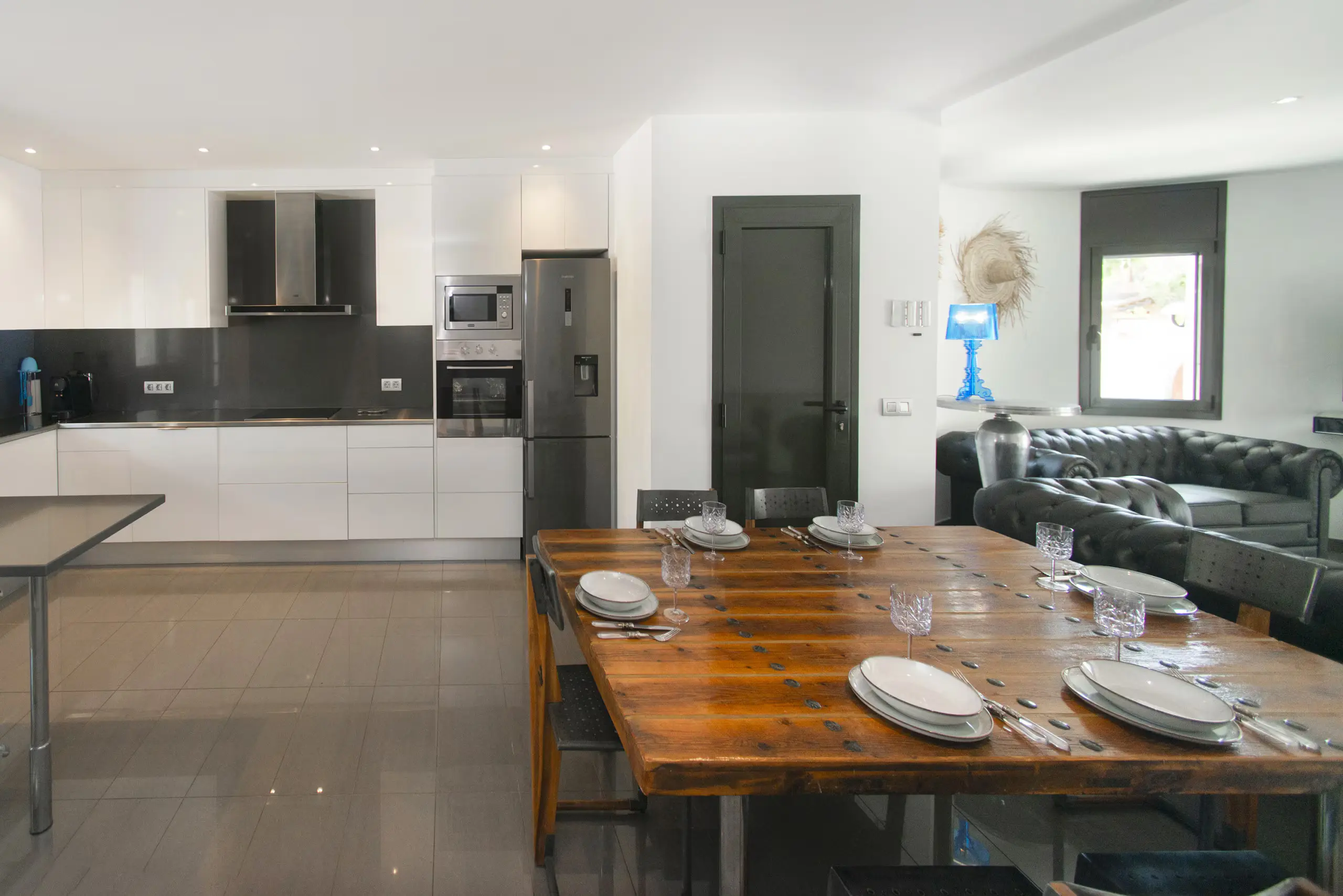 Cuisine ouverte moderne avec grande table repas et salon Chesterfield