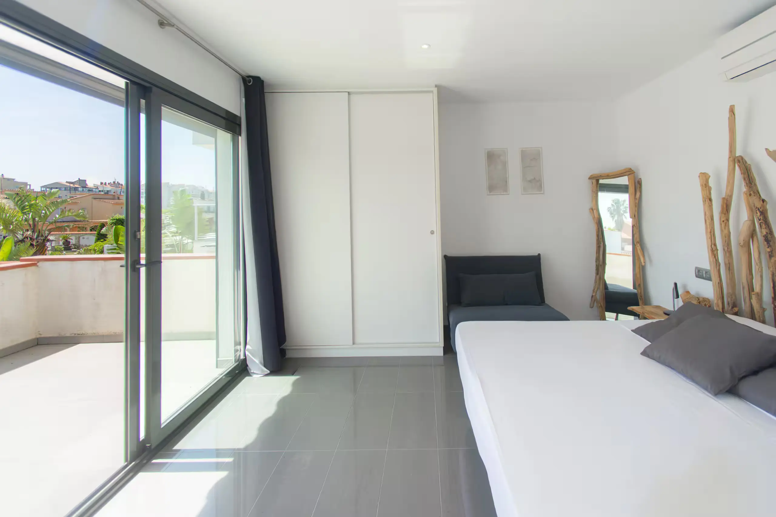 Suite avec lit double tête de lit bois flotté et accès terrasse