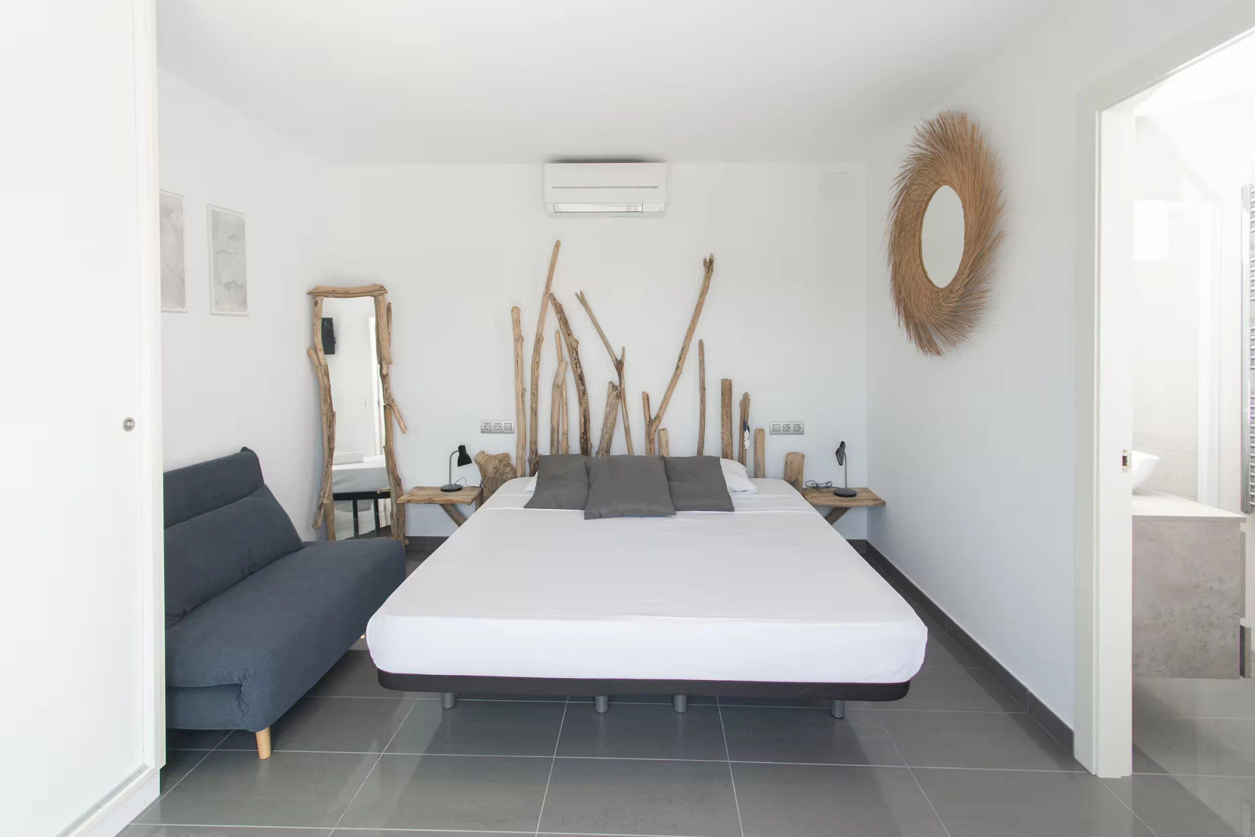 Suite de la tour ronde lit bois flotté et canapé bleu avec terrasse