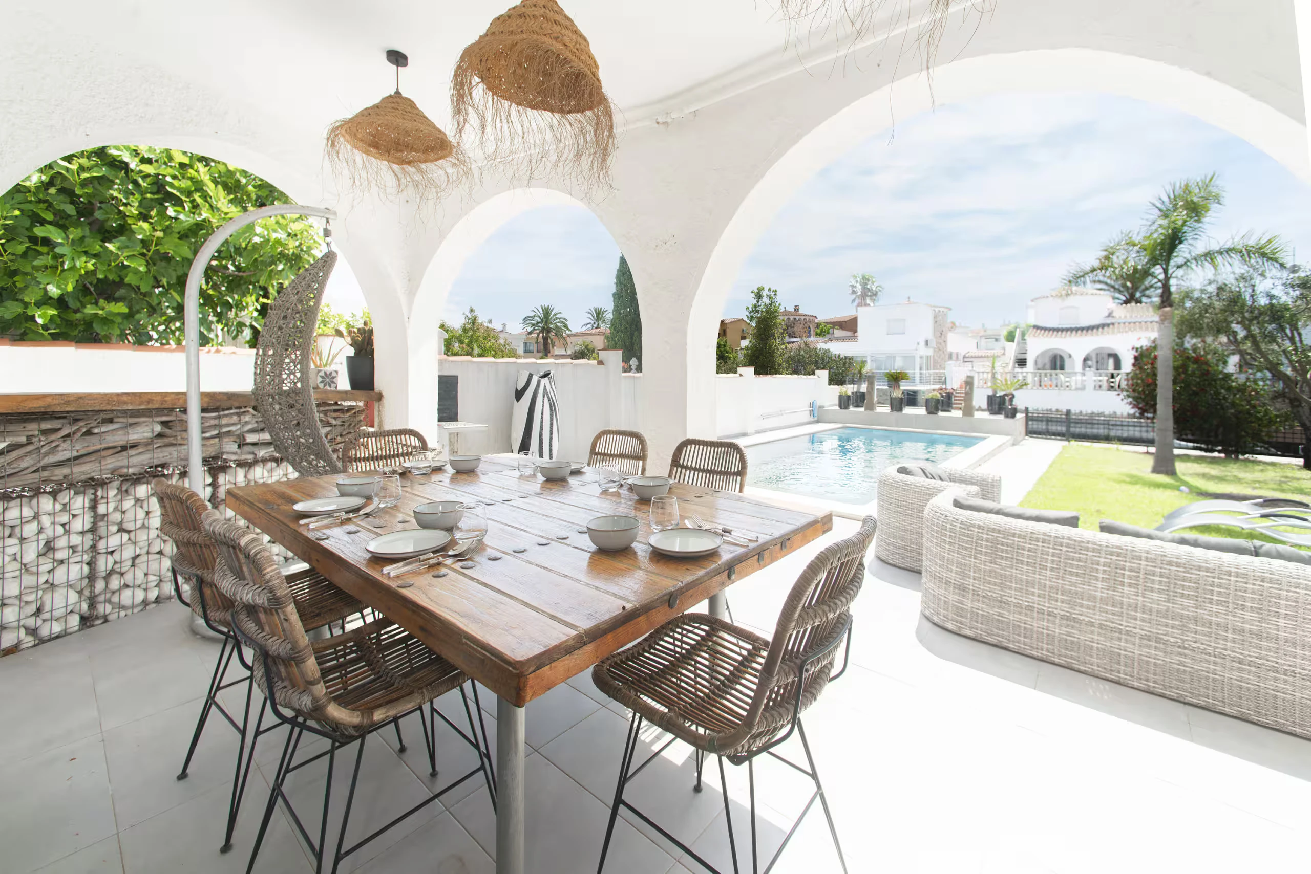 Terrasse couverte avec arches et espace repas vue sur piscine